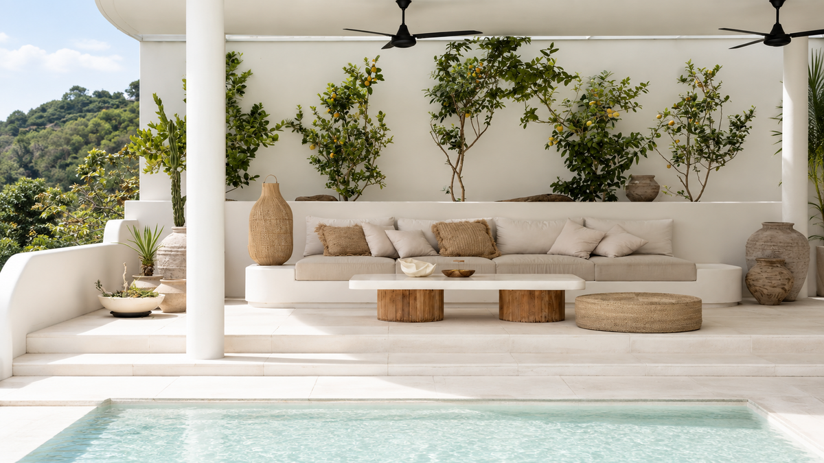Terrasse balinaise avec canapé blanc, table basse en bois et végétation luxuriante - Collection Maison de Vacances Bazar Living